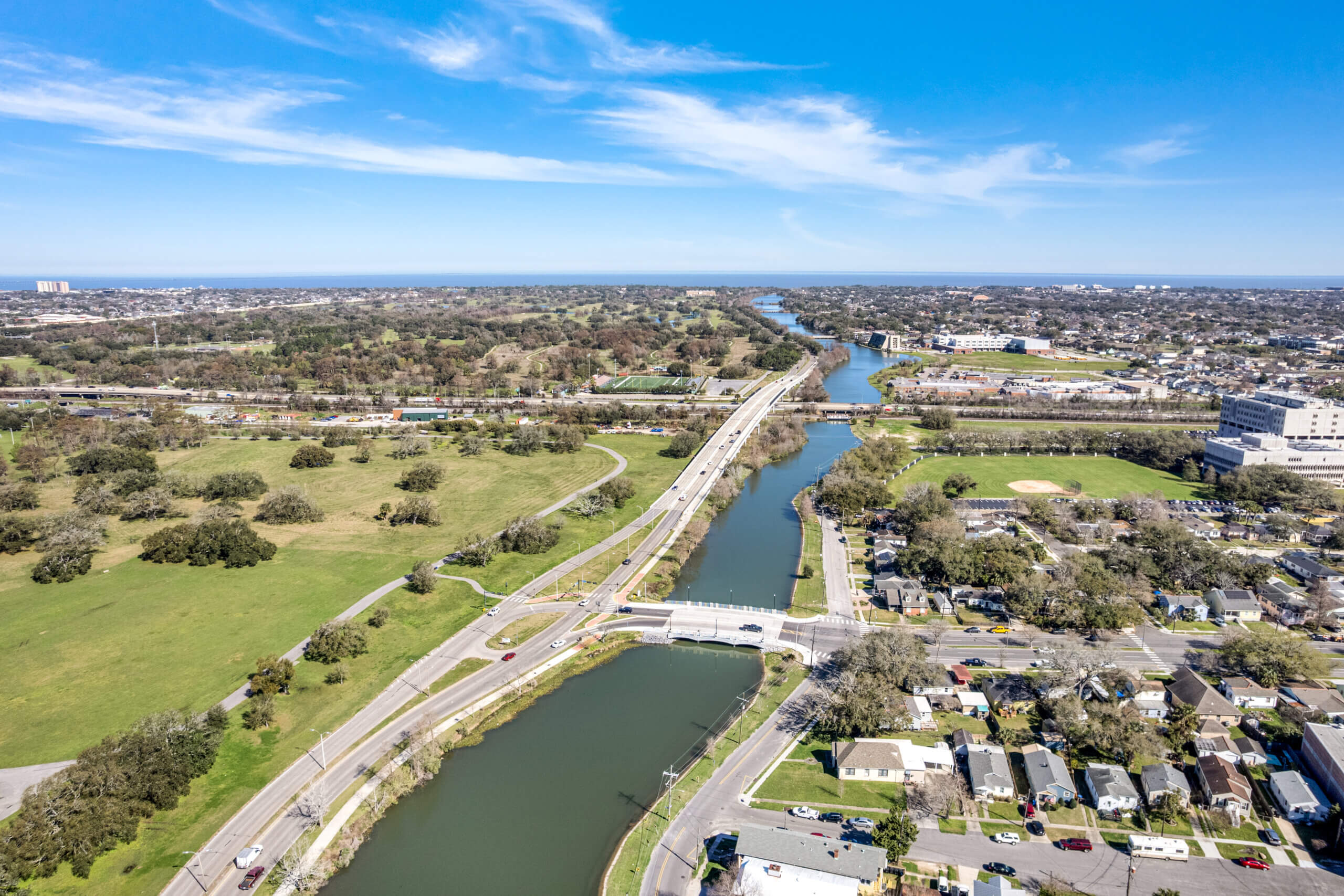 Long aerial view of Desaix Bridge crossing Bayou St. John with extended waterway.