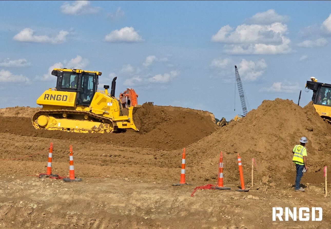 Excavators grading and moving soil at an RNGD data center construction site