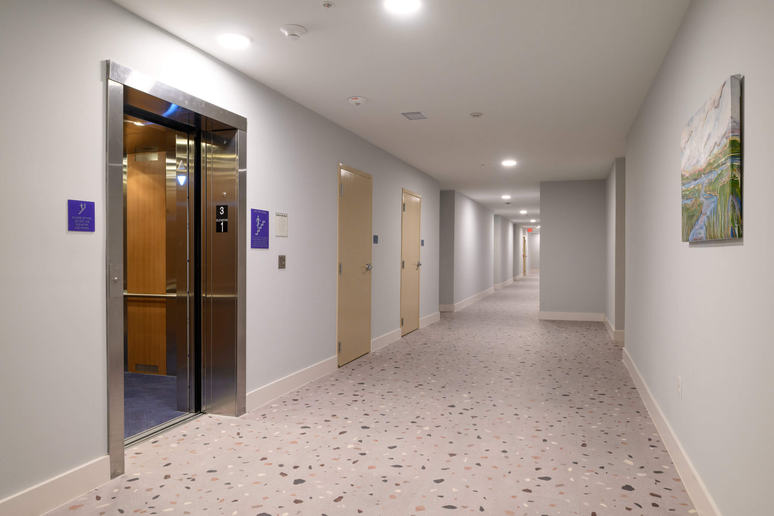 Interior corridor with elevator and polished concrete floors inside Mid City Lofts