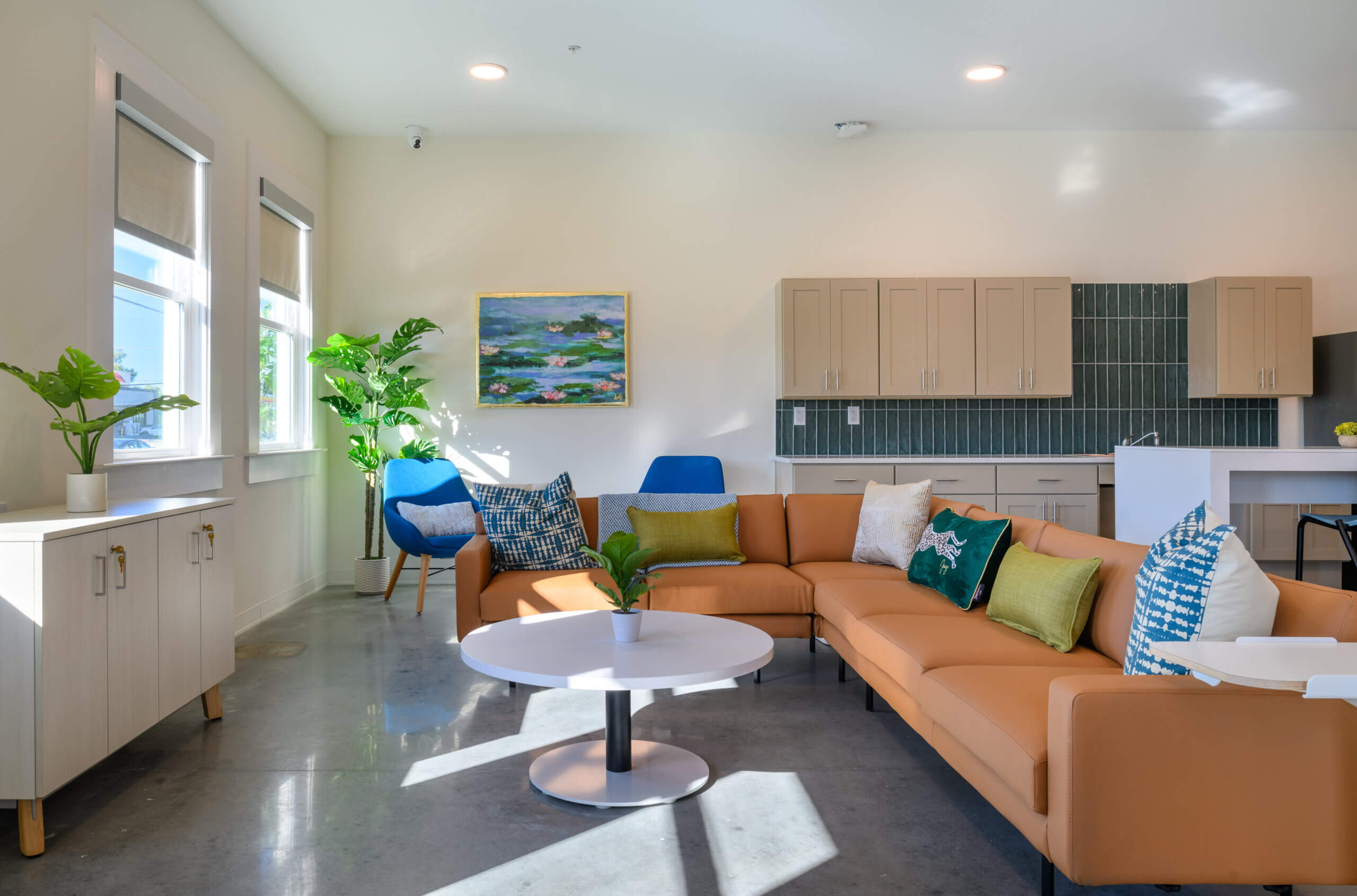 Community room with seating and kitchen area inside Mid City Lofts