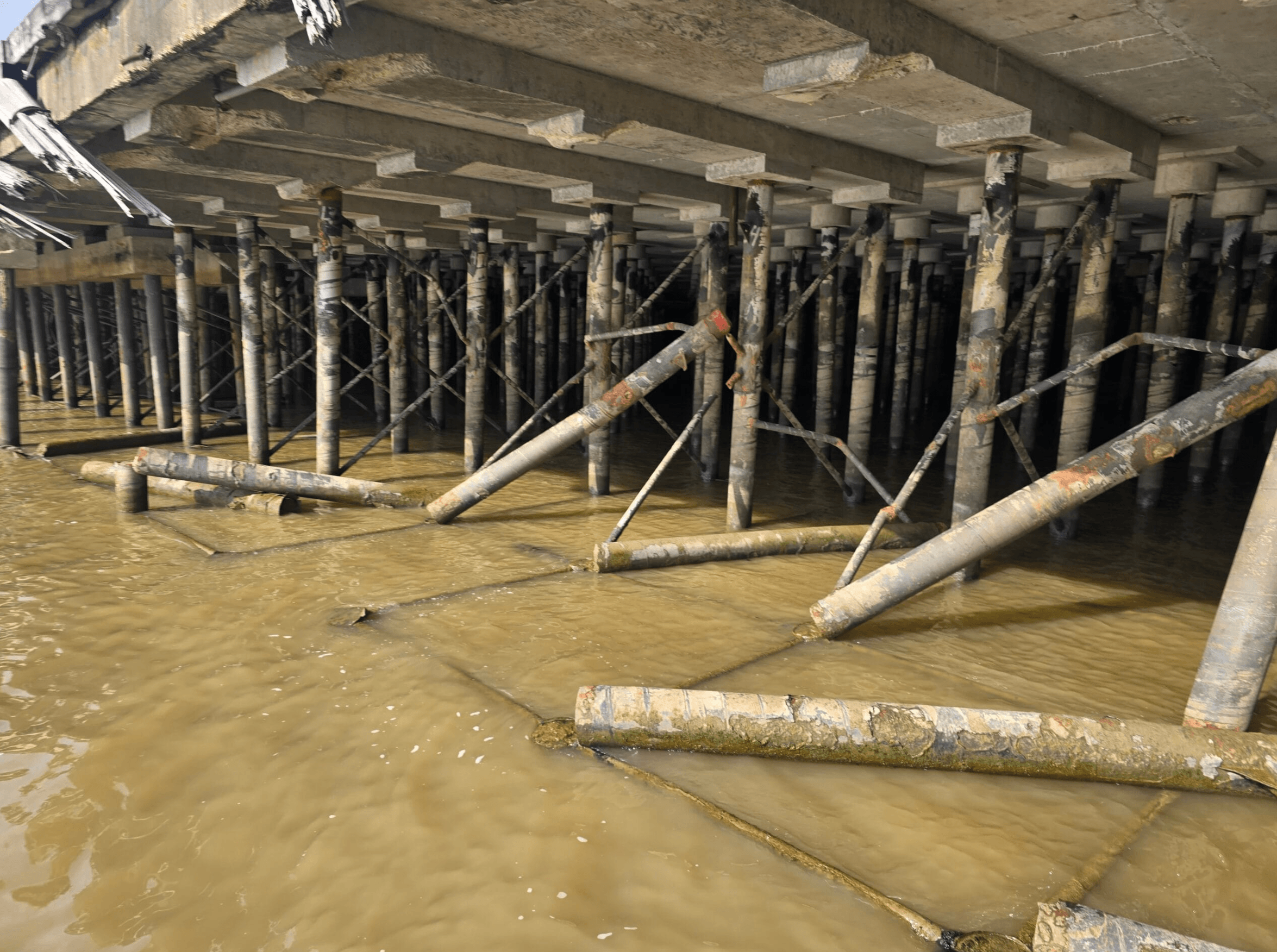 Damaged dock piles beneath Governor Nichols Wharf following a barge collision along the Mississippi River.