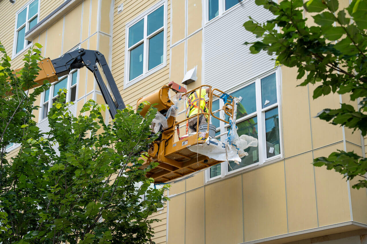 Construction worker in lift installing façade panels at Winn-Dixie Phase II